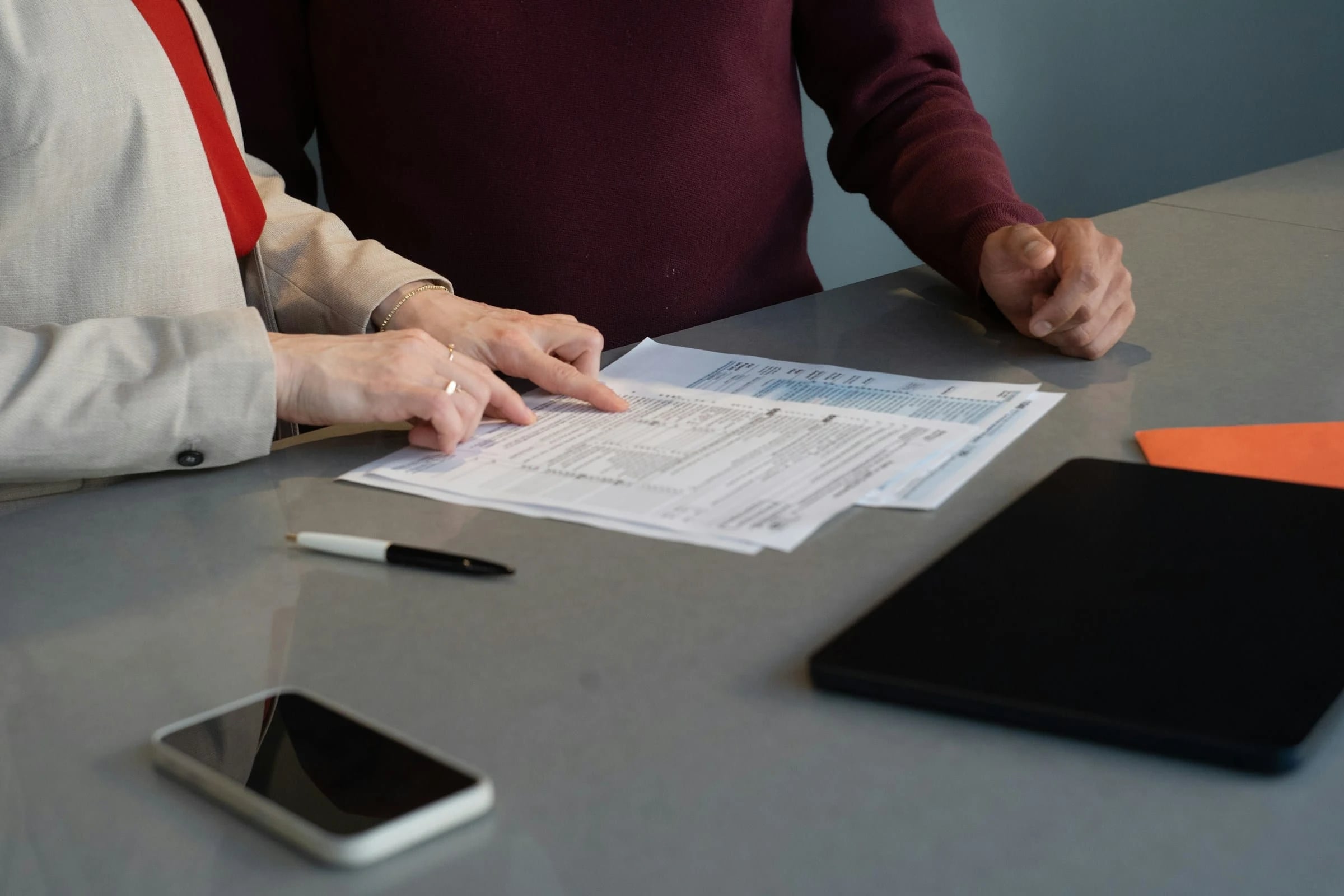 Two people reviewing billing documents at a table