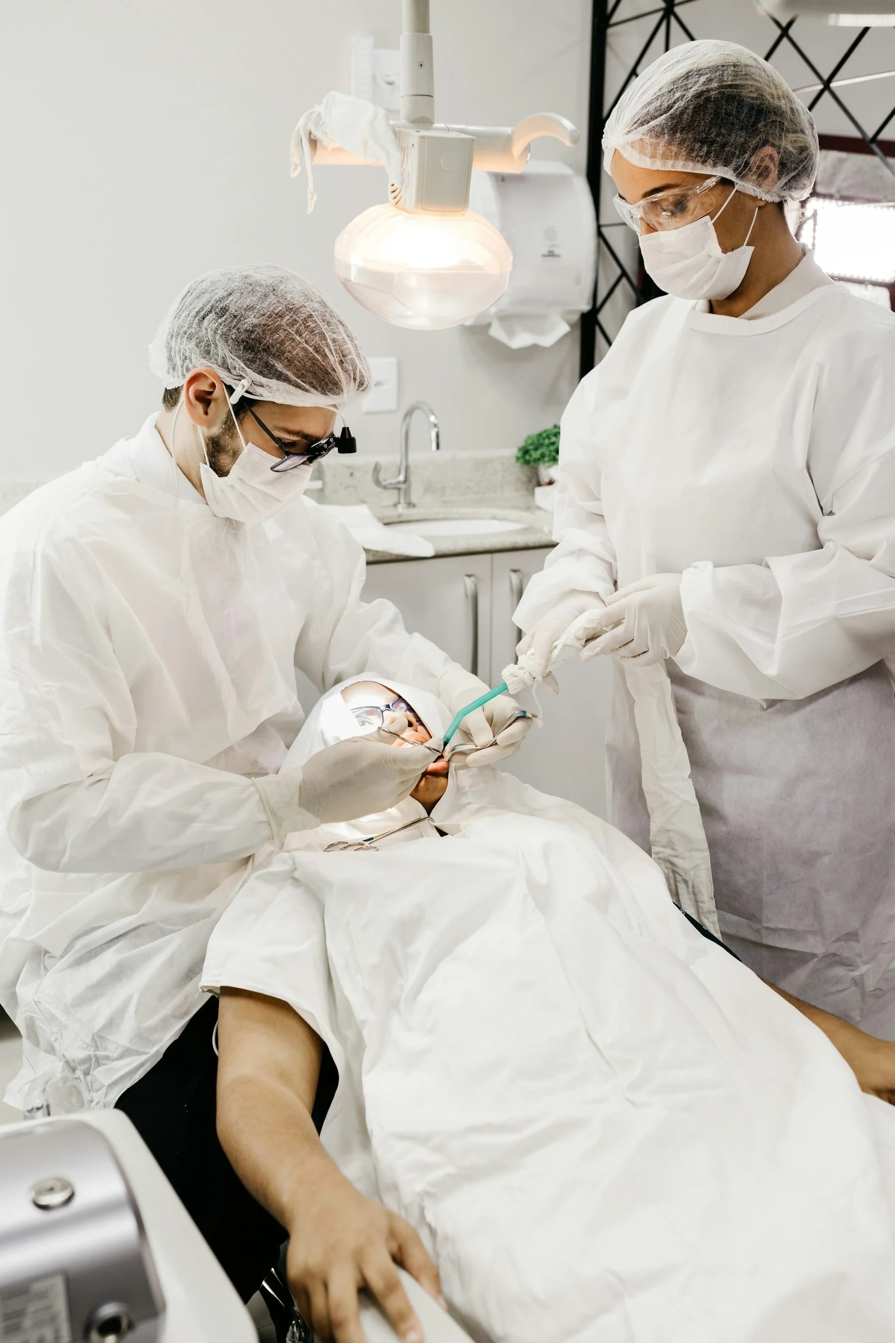 Two dentists treating a patient in a dental clinic