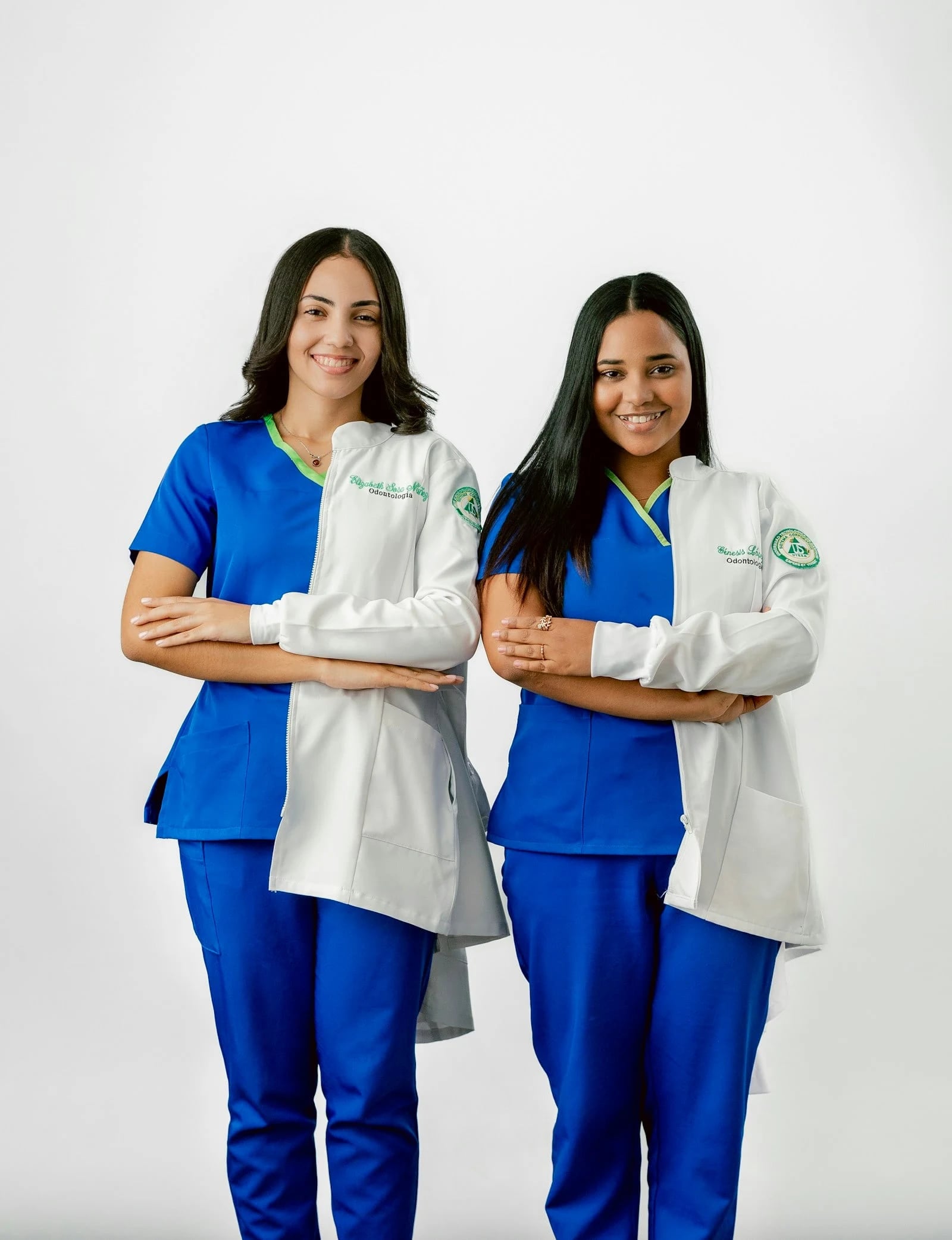Two dentists in scrubs and white coats
