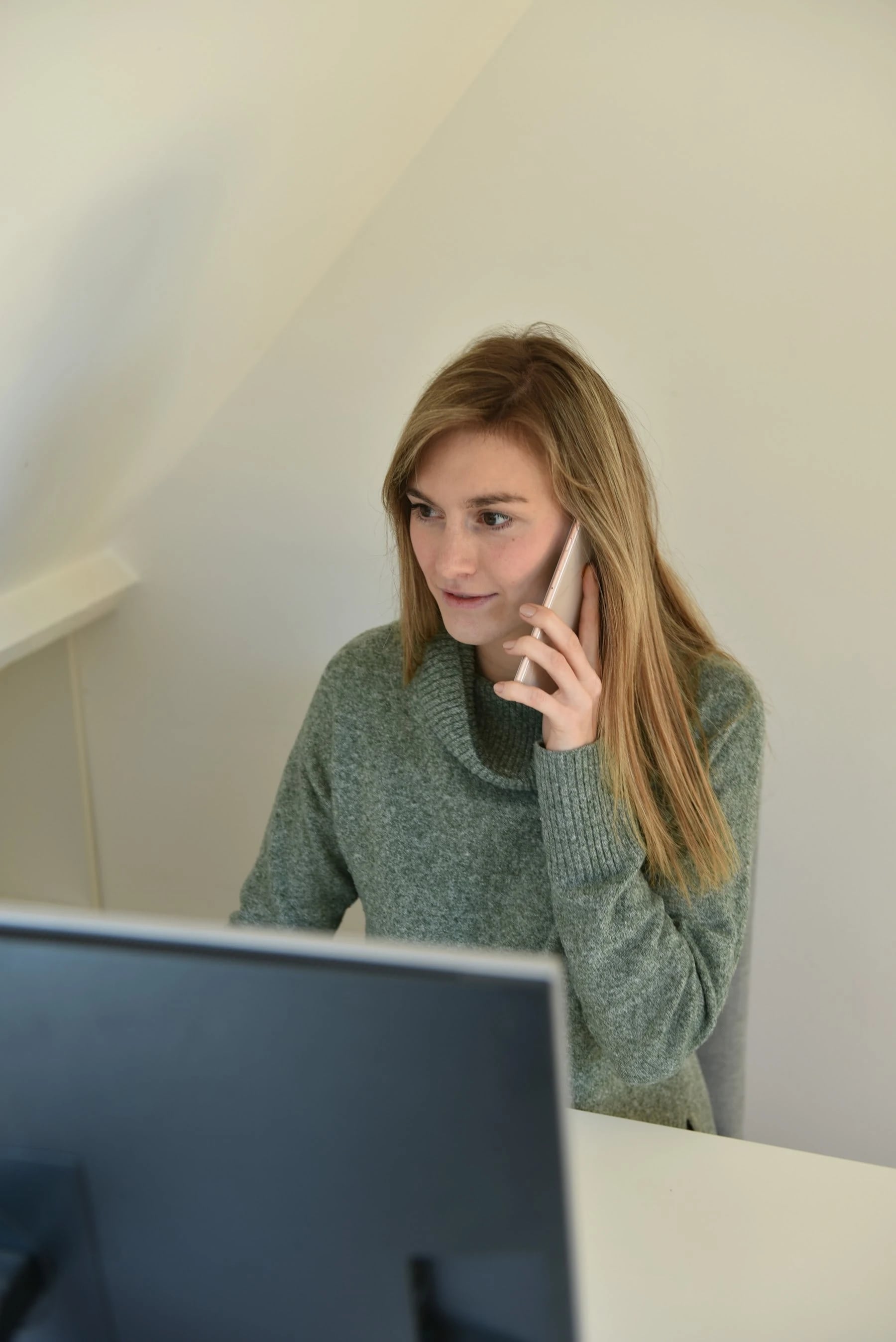 Practice team member answering a patient call at her computer